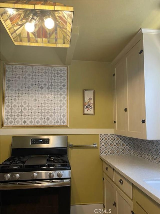 kitchen featuring stainless steel gas range and decorative backsplash