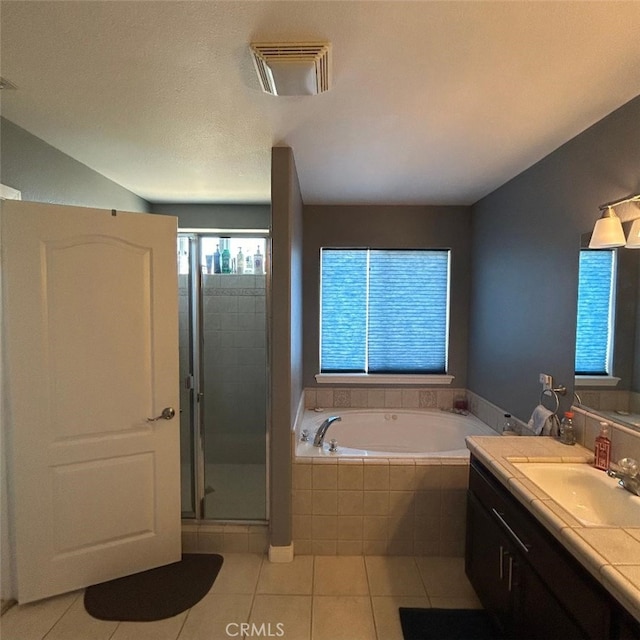 bathroom with vanity, tile patterned flooring, and plus walk in shower