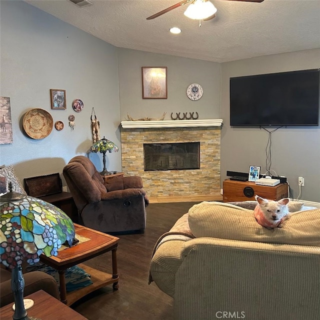 living room with a fireplace, lofted ceiling, ceiling fan, dark wood-type flooring, and a textured ceiling