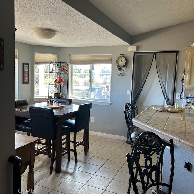 tiled dining space featuring a textured ceiling