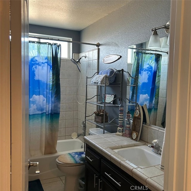 full bathroom with shower / bath combination with curtain, tile patterned flooring, vanity, toilet, and a textured ceiling