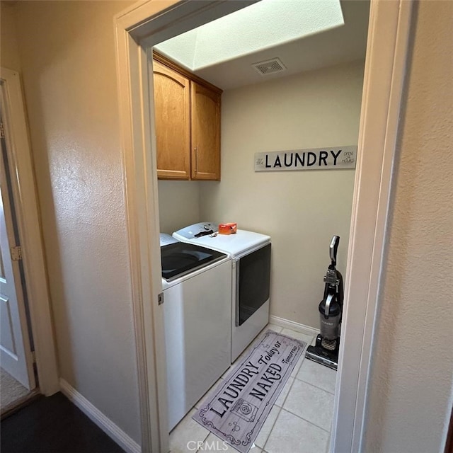 laundry room with separate washer and dryer, cabinets, and light tile patterned flooring