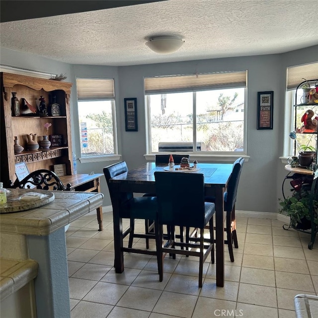 tiled dining space featuring a textured ceiling