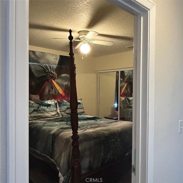 bedroom with ceiling fan, a textured ceiling, and a closet