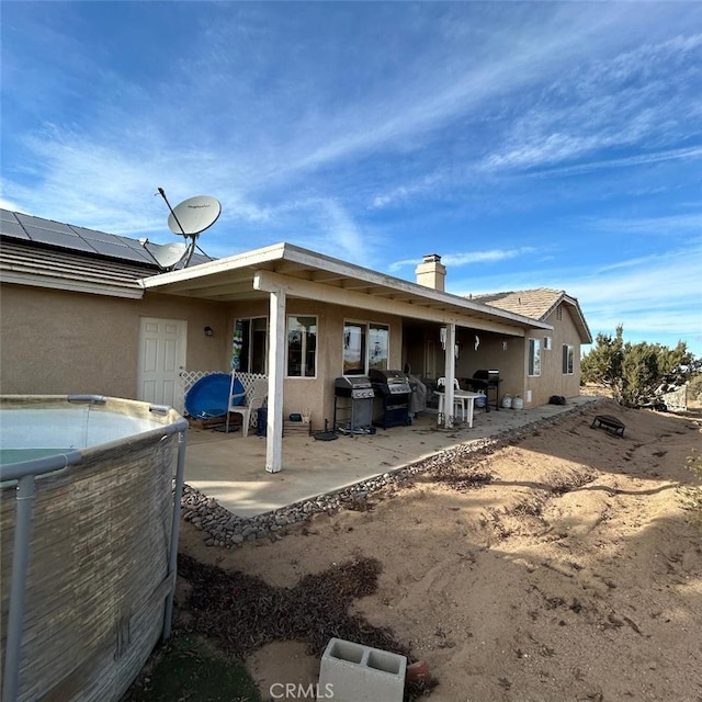 back of property featuring a patio area and solar panels