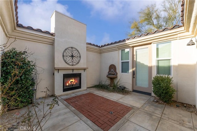 doorway to property with a patio and exterior fireplace