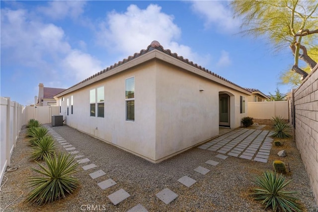 view of side of property with central AC and a patio area