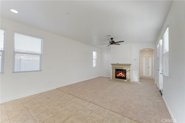 unfurnished living room with light carpet and ceiling fan