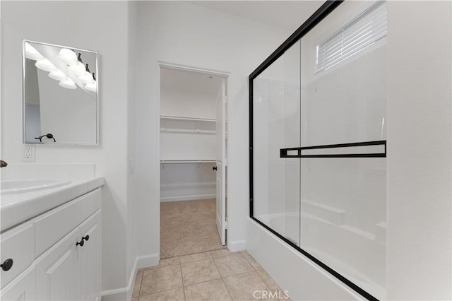 bathroom featuring tile patterned flooring, vanity, and enclosed tub / shower combo