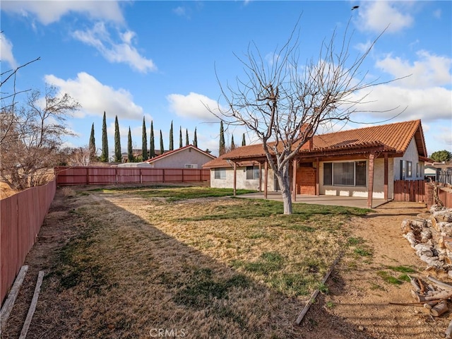 rear view of property featuring a yard and a patio