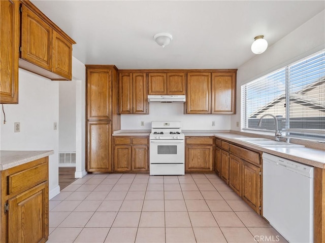 kitchen featuring light tile patterned flooring, sink, and white appliances