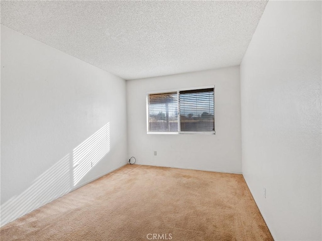 carpeted empty room featuring a textured ceiling