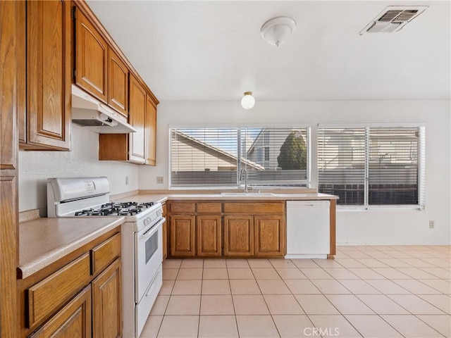 kitchen with white appliances, sink, and light tile patterned floors