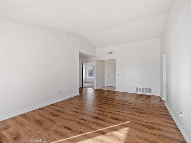 unfurnished room with lofted ceiling and hardwood / wood-style floors