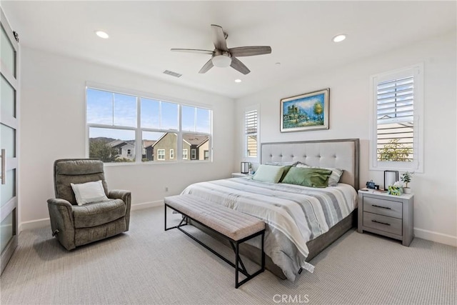 bedroom featuring light carpet, multiple windows, and ceiling fan