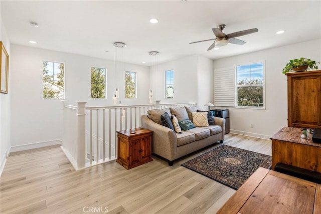 living room featuring ceiling fan, plenty of natural light, and light wood-type flooring