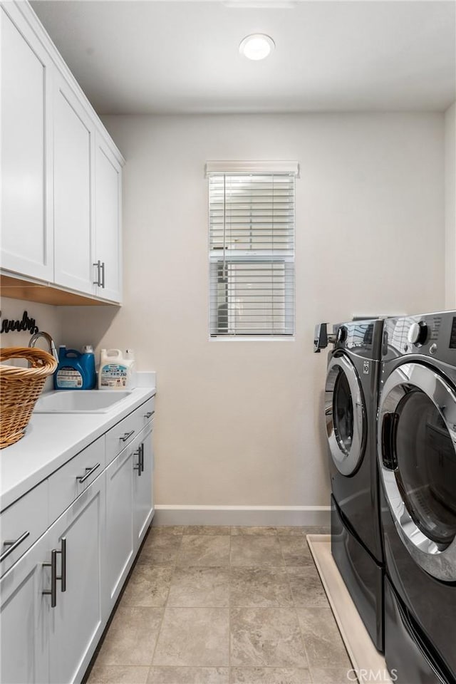 washroom featuring cabinets, sink, and washing machine and dryer