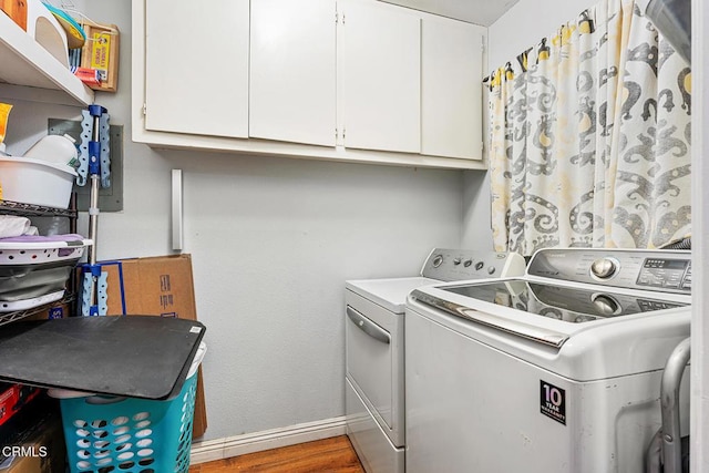 laundry room featuring cabinets, hardwood / wood-style flooring, and washer and clothes dryer