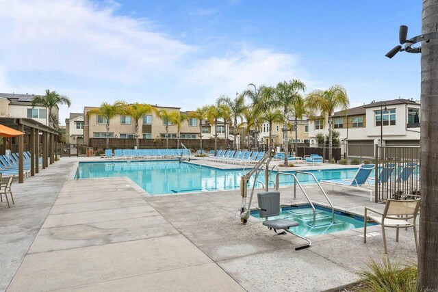 view of swimming pool featuring a hot tub and a patio area