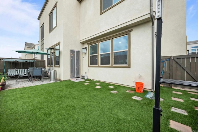 back of property with a patio and a yard