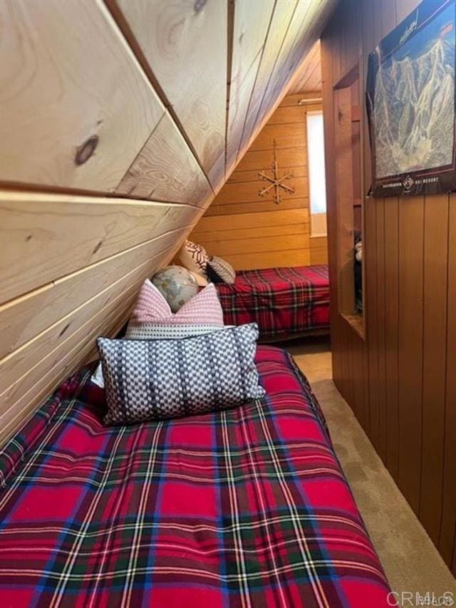 bedroom with wooden walls, vaulted ceiling, and carpet flooring