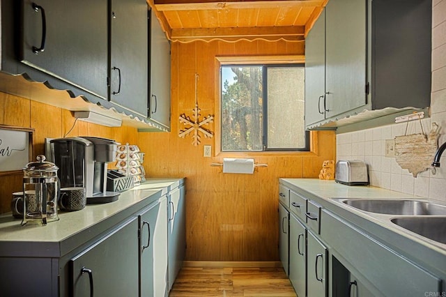 kitchen featuring tasteful backsplash, sink, and wooden walls