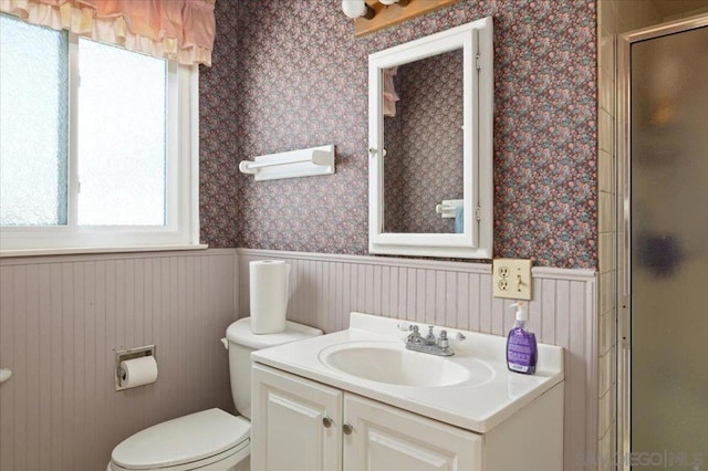 bathroom with vanity, toilet, and a shower with shower door