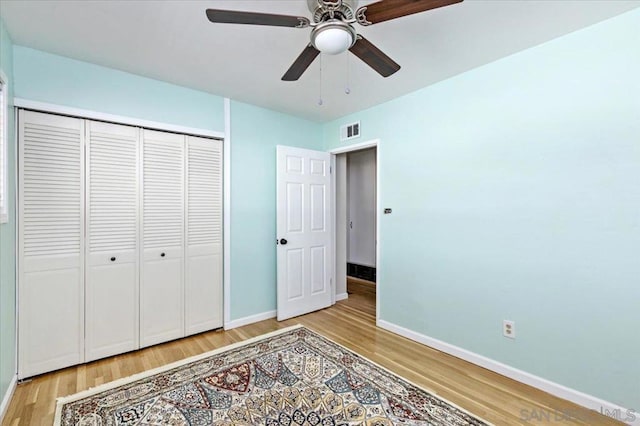 unfurnished bedroom with hardwood / wood-style floors, a closet, and ceiling fan