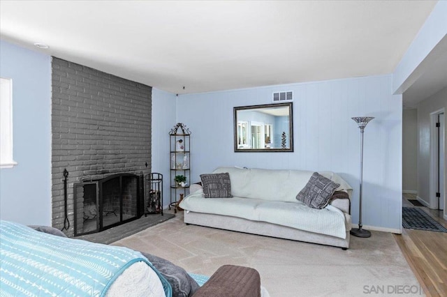 living room with hardwood / wood-style flooring and a brick fireplace