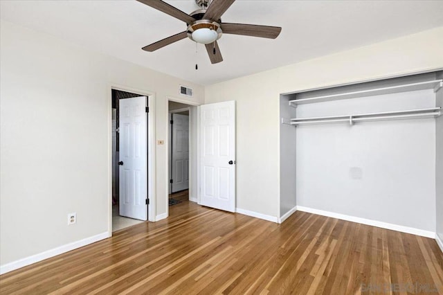 unfurnished bedroom with hardwood / wood-style flooring, ceiling fan, and a closet