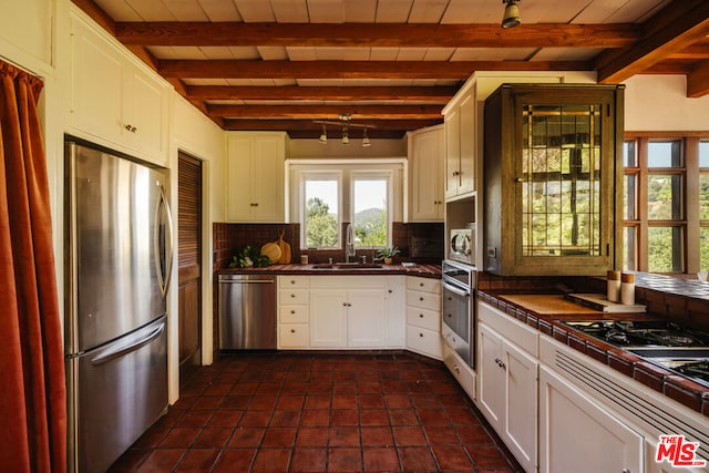 kitchen with sink, tasteful backsplash, tile countertops, stainless steel appliances, and white cabinets