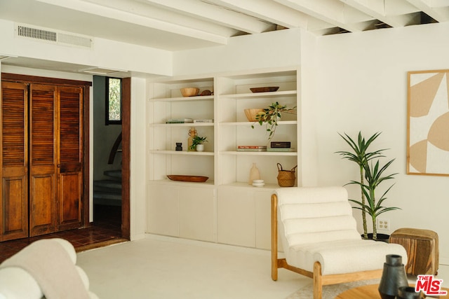 living area featuring beamed ceiling