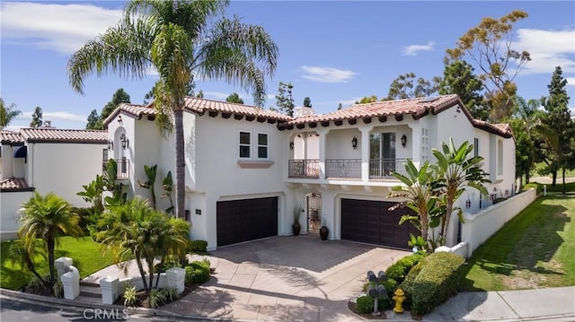 mediterranean / spanish house featuring a garage and a balcony