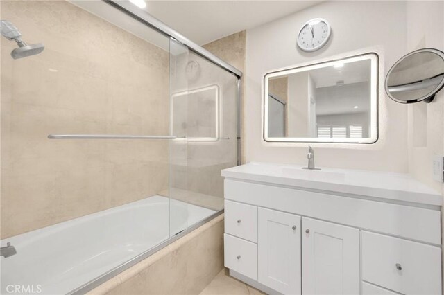 bathroom with vanity and shower / bath combination with glass door