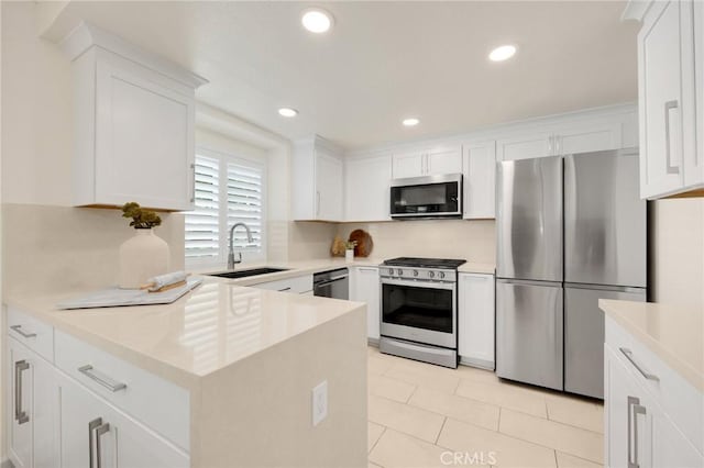 kitchen featuring sink, light tile patterned floors, stainless steel appliances, and white cabinets