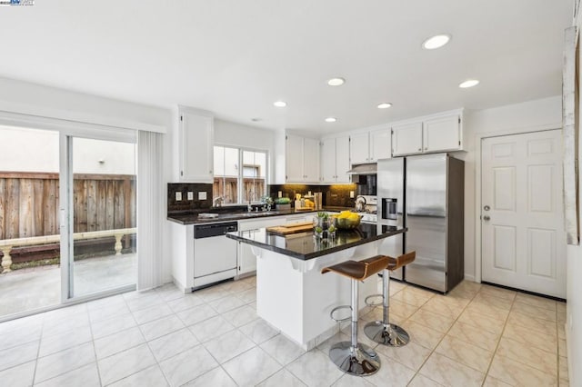 kitchen with a breakfast bar, a center island, stainless steel fridge with ice dispenser, white dishwasher, and white cabinets