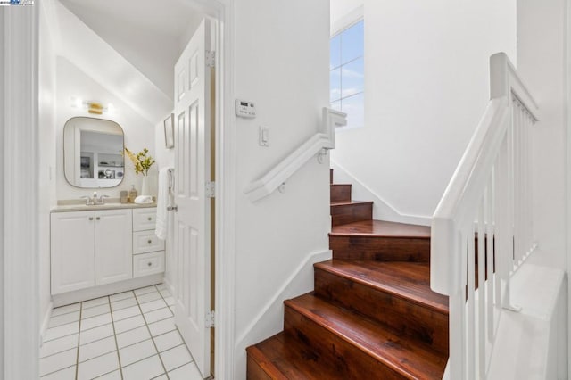 staircase featuring tile patterned flooring and sink