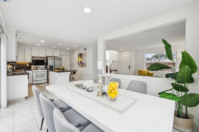 dining space with sink and light tile patterned floors