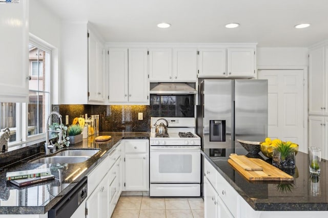 kitchen with sink, stainless steel fridge, gas range gas stove, white cabinets, and exhaust hood