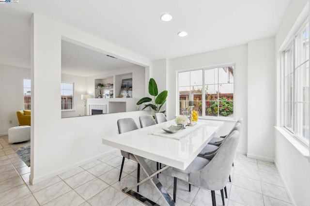 dining room featuring light tile patterned flooring and a fireplace