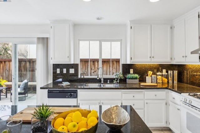 kitchen with white cabinetry, sink, dark stone countertops, decorative backsplash, and white appliances