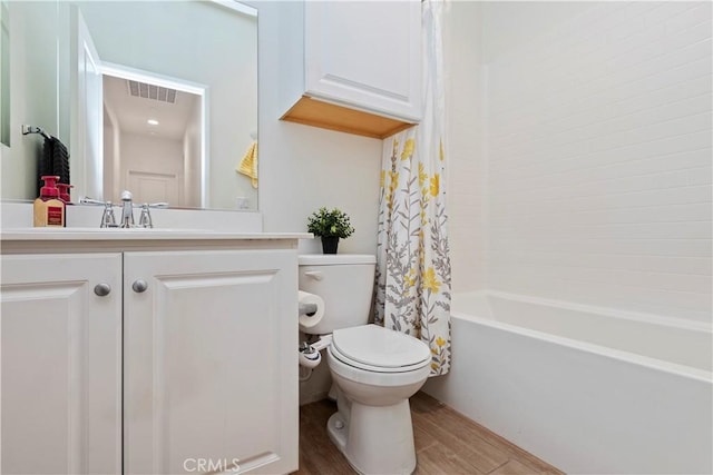 full bathroom featuring shower / bath combo, hardwood / wood-style floors, vanity, and toilet