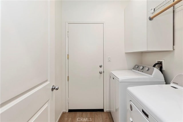 washroom with cabinets, light wood-type flooring, and independent washer and dryer