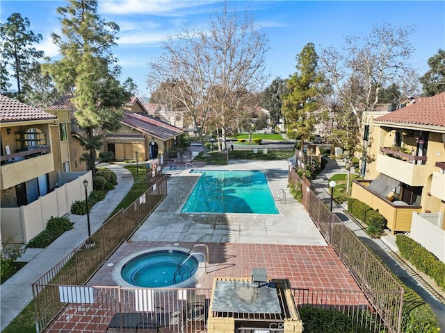 view of swimming pool featuring a community hot tub and a patio area