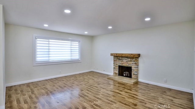 unfurnished living room featuring wood-type flooring and a fireplace