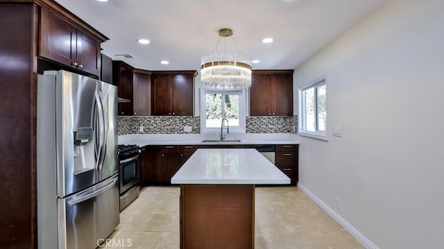 kitchen with sink, a center island, hanging light fixtures, stainless steel appliances, and backsplash