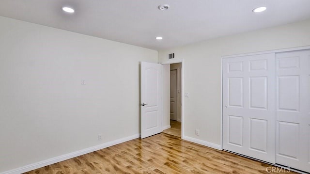 unfurnished bedroom featuring light hardwood / wood-style floors and a closet