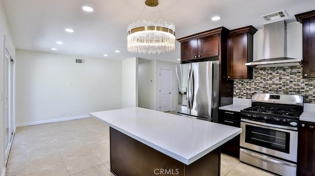 kitchen with a kitchen island, tasteful backsplash, appliances with stainless steel finishes, and wall chimney range hood