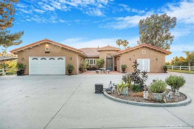 mediterranean / spanish-style house with a garage