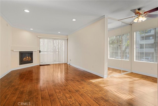 unfurnished living room with crown molding, wood-type flooring, and ceiling fan